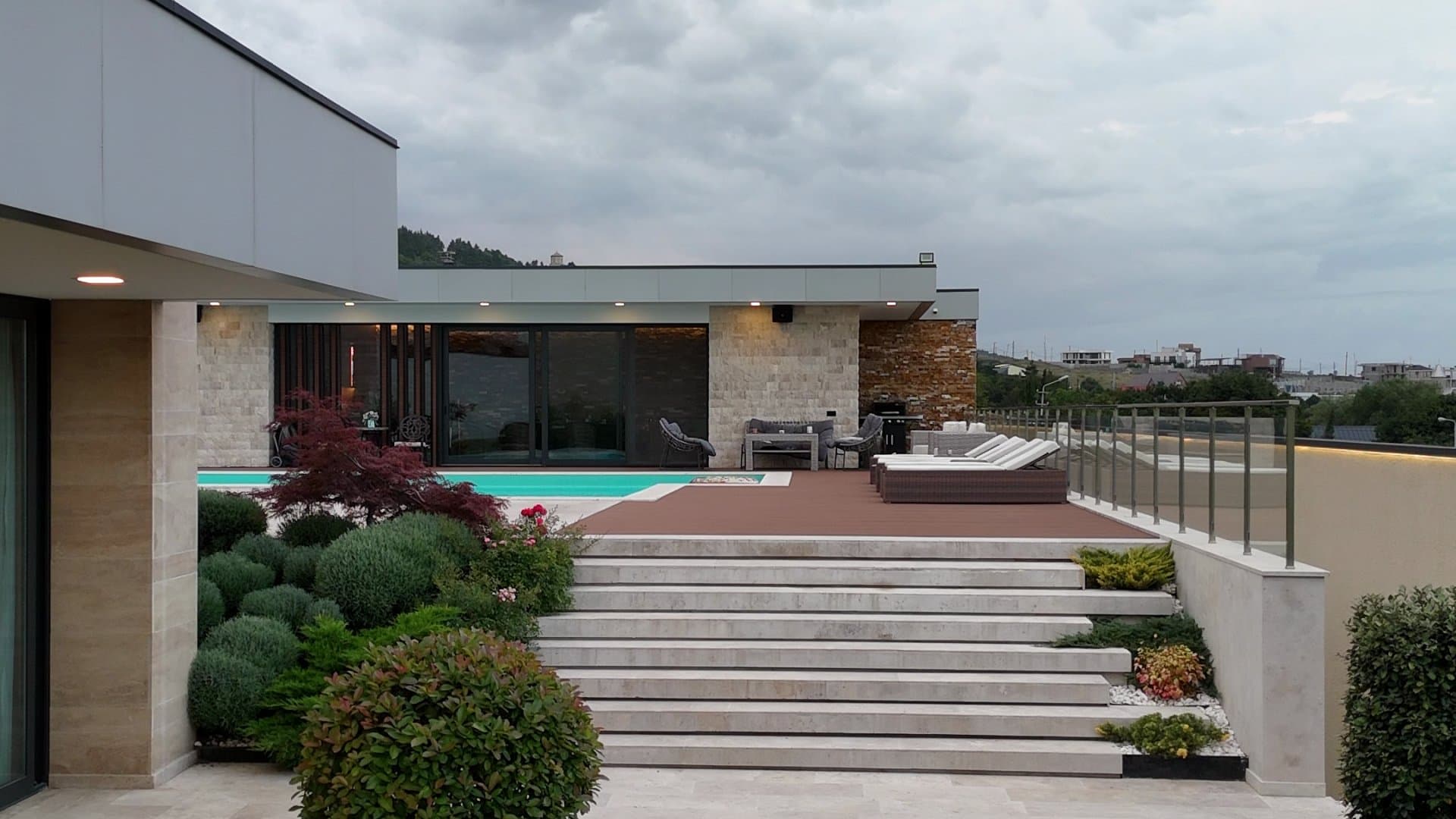 Stone steps rising between clipped planting to the pool terrace and the house