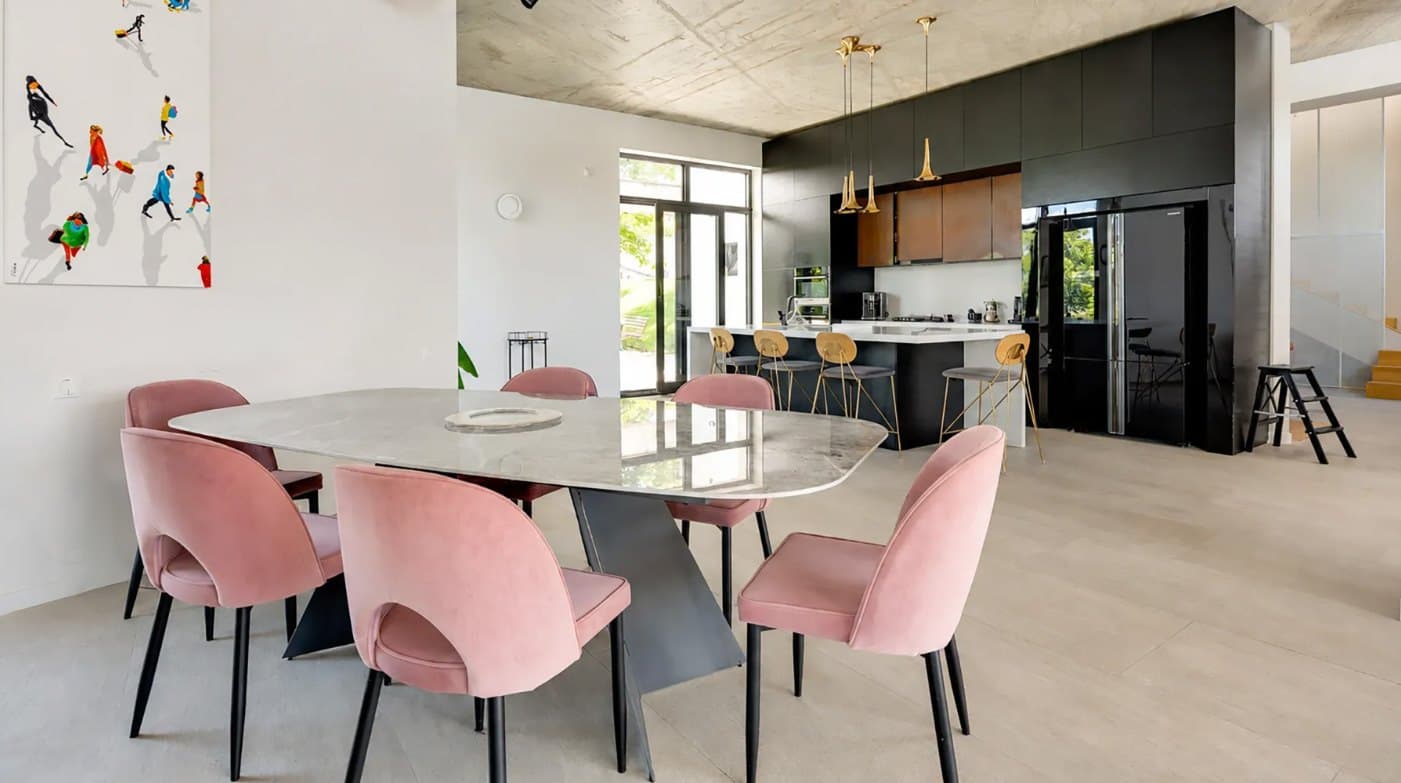 The dining table, with the kitchen and its island beyond.