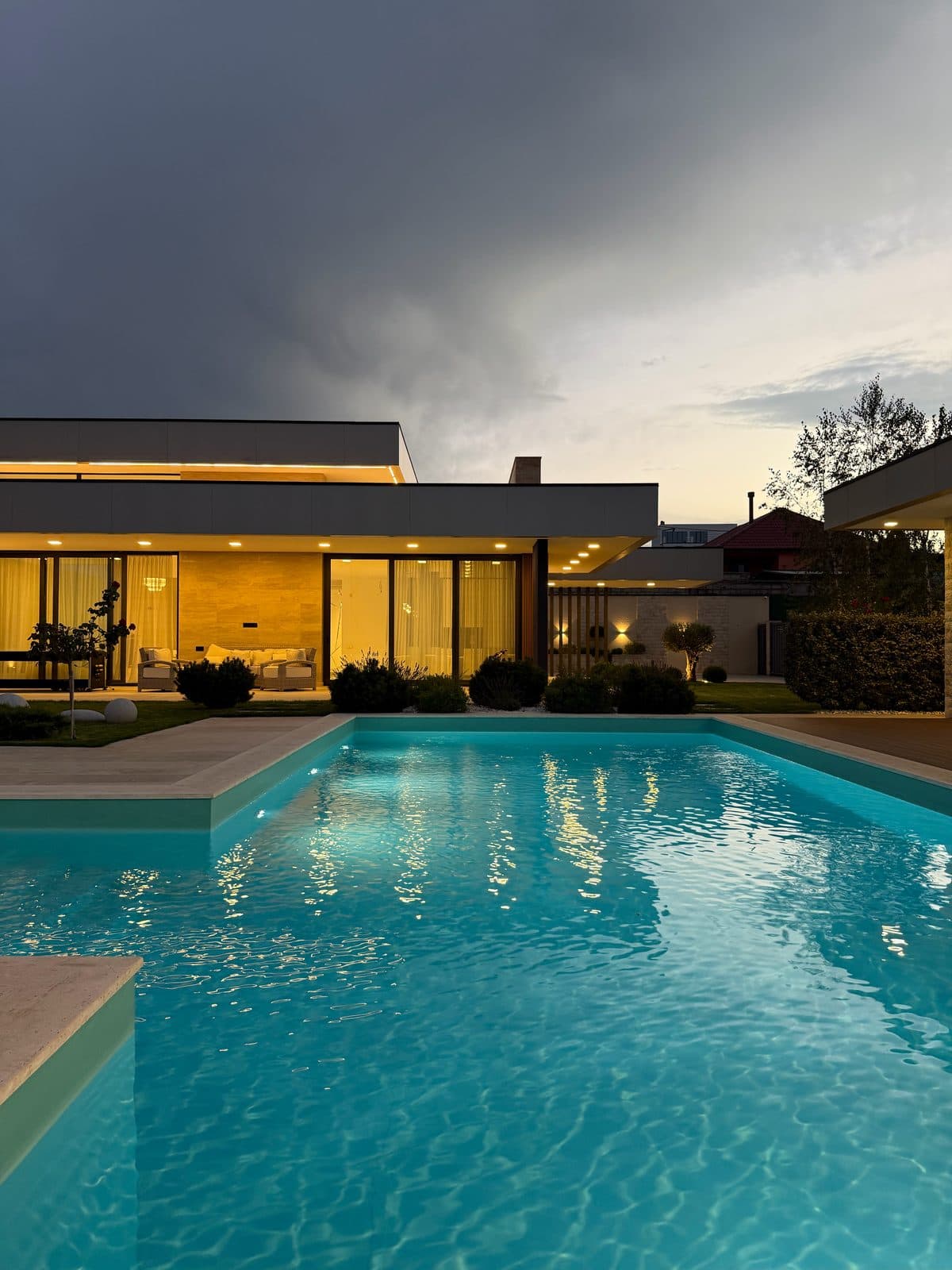 The pool and the house, lit at dusk.