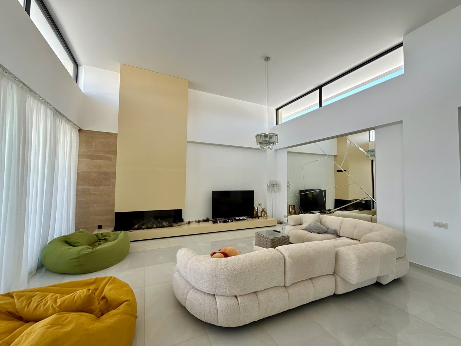 The central living volume, under a double-height ceiling, with the fireplace.
